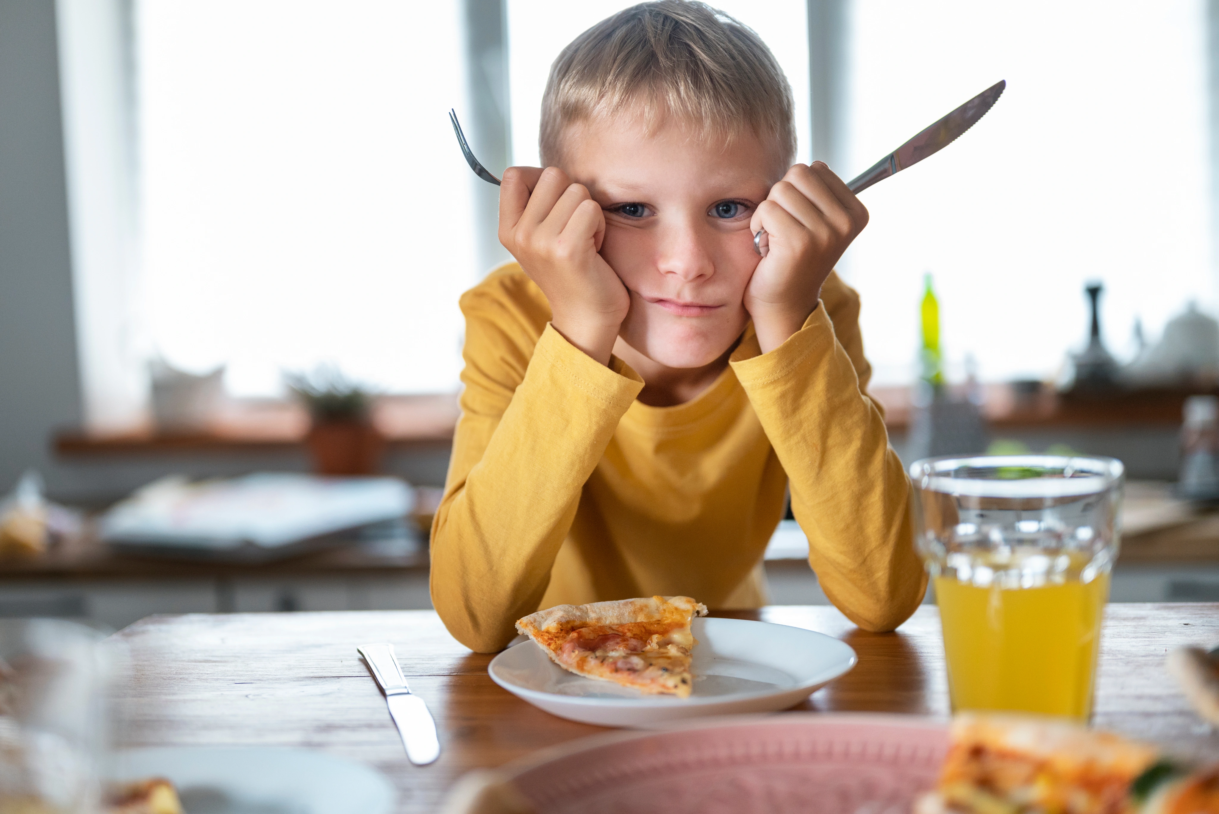 Criança à mesa recusando a comida